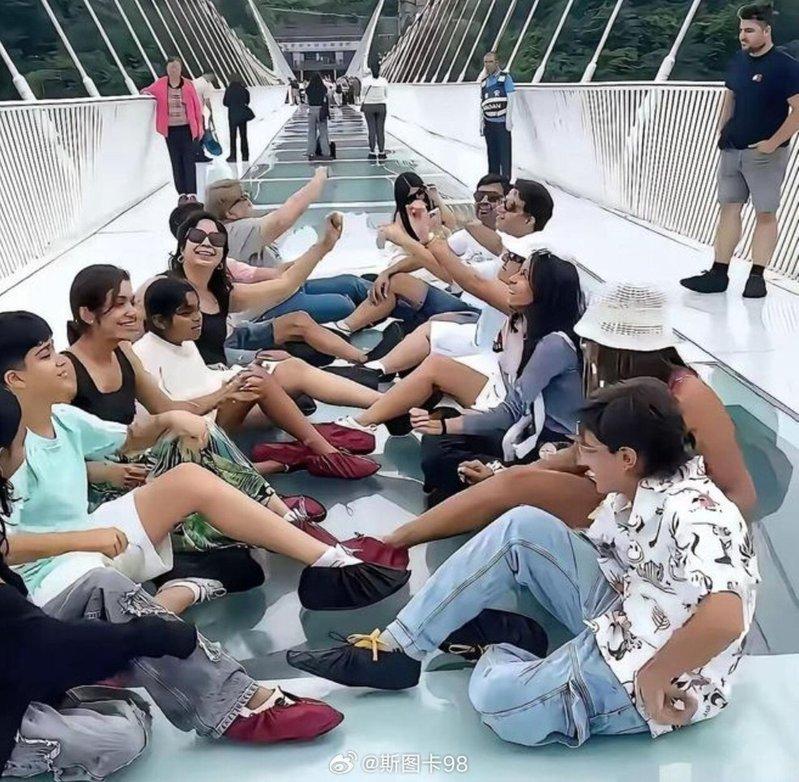 多名印度游客在狭窄的玻璃栈道上长时间席地而坐、拍照并大声唱歌嬉闹。(取材自微博)
