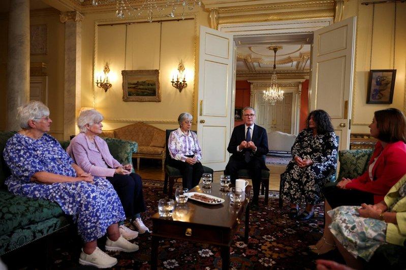 英国首相施凯尔(左四)2日于唐宁街首相官邸,与相关人士讨论过往的「强制收养」制度...