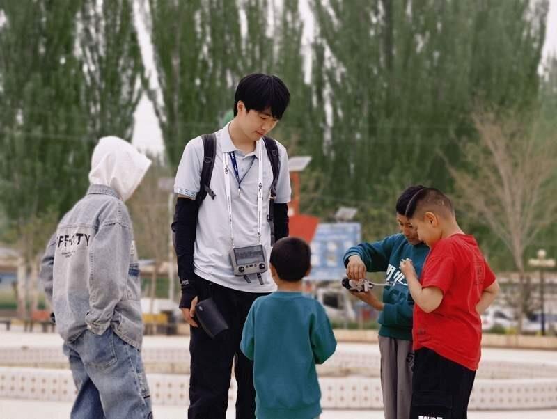 沈嘉楠和皮山县塔吉克斯坦民族自治乡小朋友在一起。（取材自新京报／受访者供图）