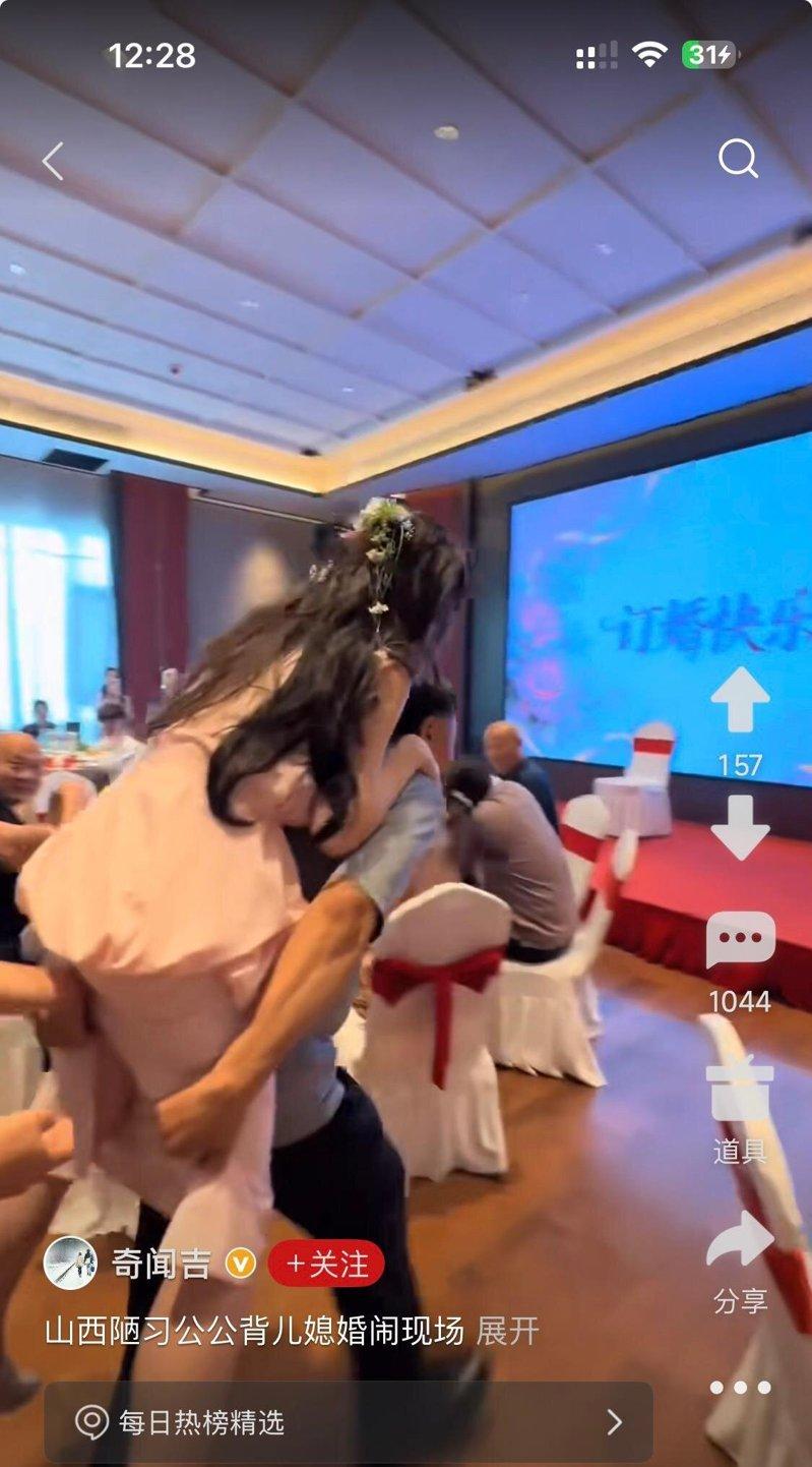 据网民发出现场视频,公公揹儿媳时,后方有人伸出手触摸新娘臀部。(取材自微博)