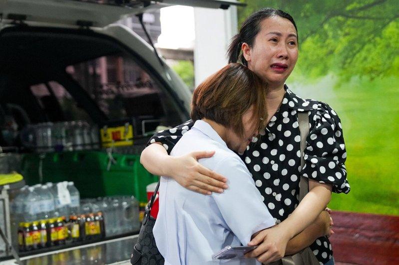 泰国曼谷一家酒吧发生致命火灾后,罹难者家属在警察医院太平间领取遗体时悲痛不已。(...