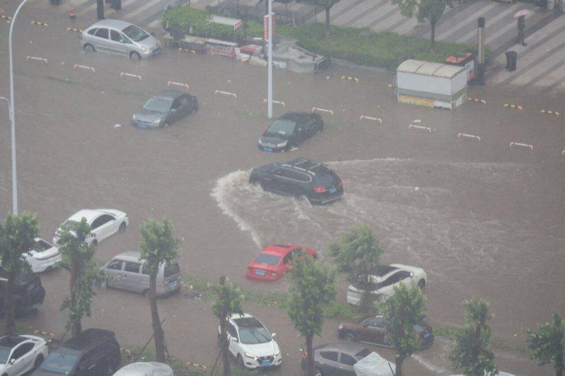 受暴雨影响,辽宁省沈阳市区部分街道路面积水,汽车在水中缓慢行驶。(中新社)