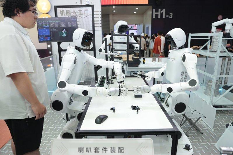 7月16日,上海世博展览馆,多台机器人协同展示喇叭套件装配。 (中新社)