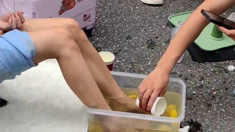 现场有粉丝拿杯子舀起「新鲜脚汁柠檬水」饮用，吸引大批人围观及拍片  。（视频截屏...