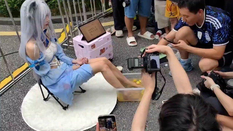 一名Coser将双脚放入装有柠檬片的水盆内。（视频截屏）