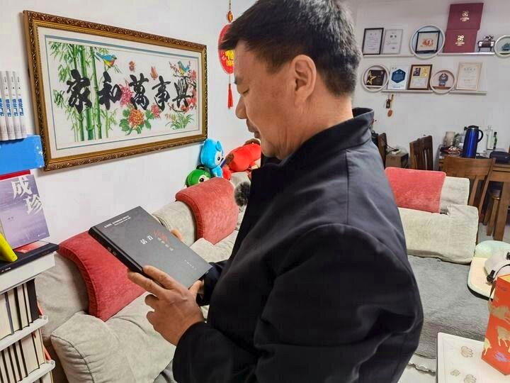 王计兵从书架上拿出「活着」。（新华社）