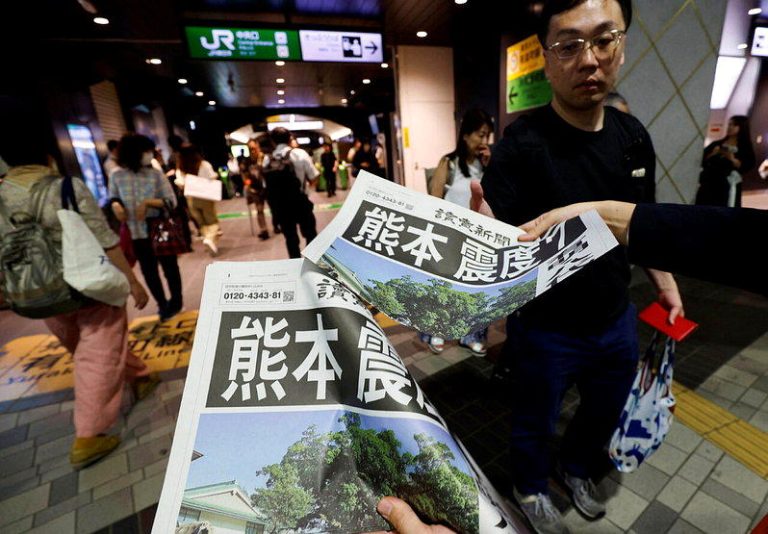 日本熊本县28日发生规模7.1地震，一名东京市民收到有关地震灾情的号外。（路透）