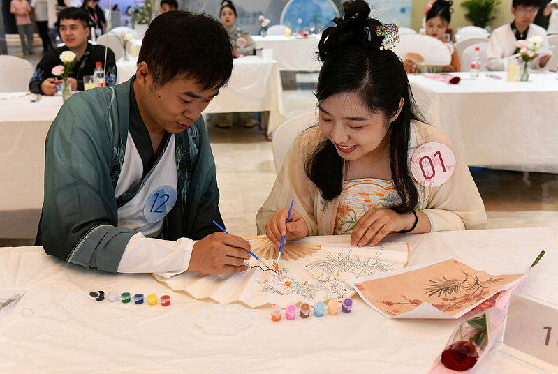 一场相亲活动,两位青年共画折扇。示意图。(中新社)