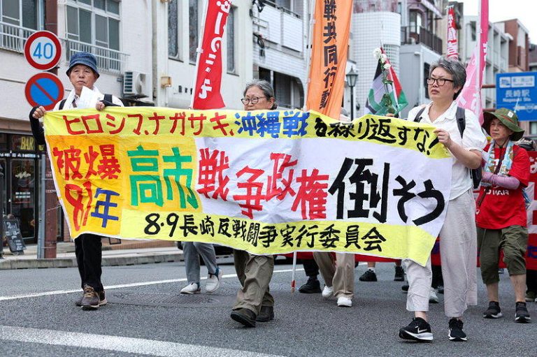 日本民众8月9日在长崎和平公园附近参加反战游行。(新华社)