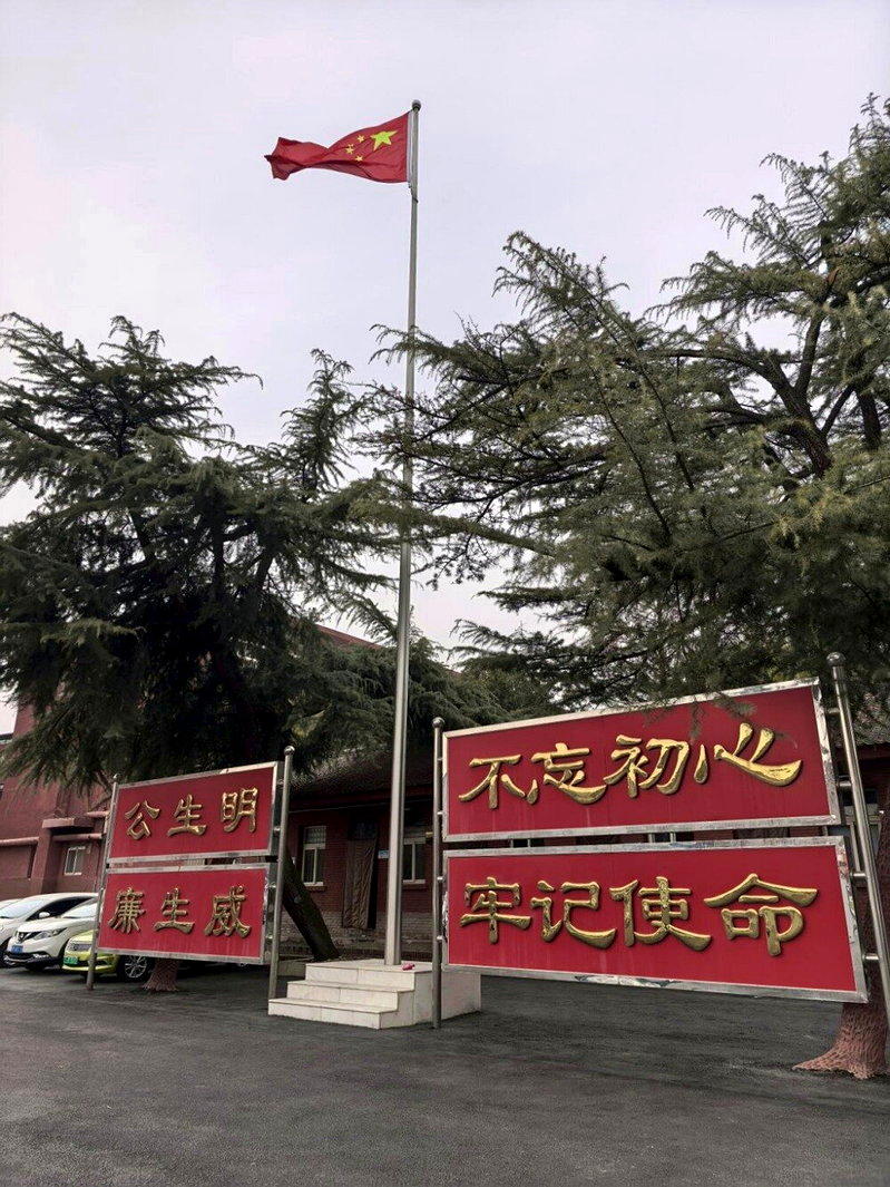 升旗台旁竖立着「公生明、廉生威」、「不忘初心、牢记使命」等牌子。（取材自澎湃新闻...