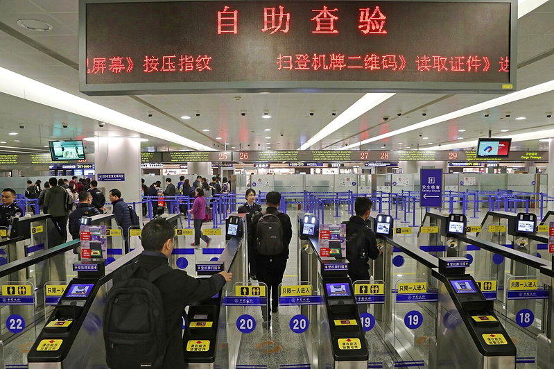 图为旅客在上海浦东机场出境大厅内扫登机牌、刷护照、按指纹拍照片通关。示意图，与新...
