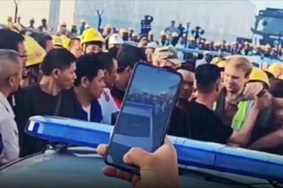 中国工人在俄罗斯讨薪被带走,上千工友围住警车声援现场。(视频截屏 )