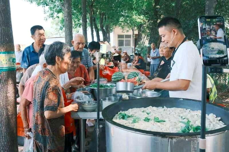7月下旬的沟李村，老人们排队打饭。（取材自新京报）