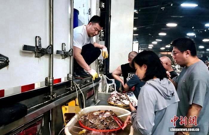 游客在浙江宁波购买梭子蟹。(取材自中国新闻网)