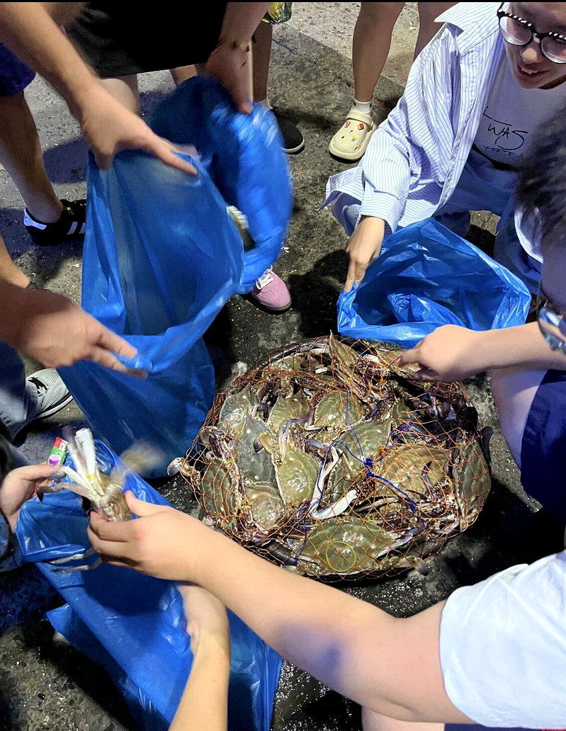 捕蟹船刚卸下渔获,年轻人就上前分配各自的「拼蟹」数量。(取材自小红书)