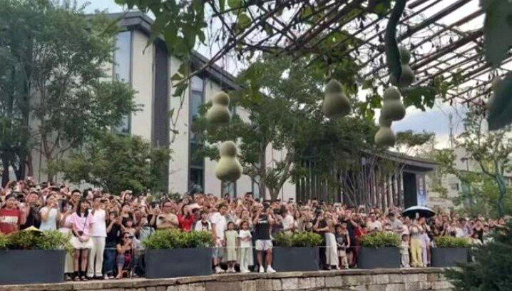 大量游客聚集在陈爷爷家对面的河岸打卡,陈爷爷不时走出家门与大家交互。(取材自鲁中...