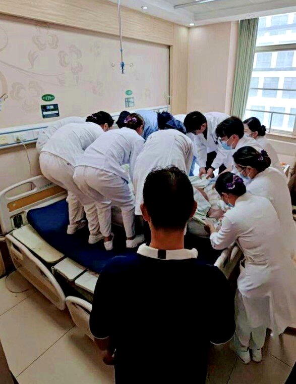 转入普通病房时,12位医护人员合力才将晓洲转运到两张病床拼制的特殊病床上。(取材...