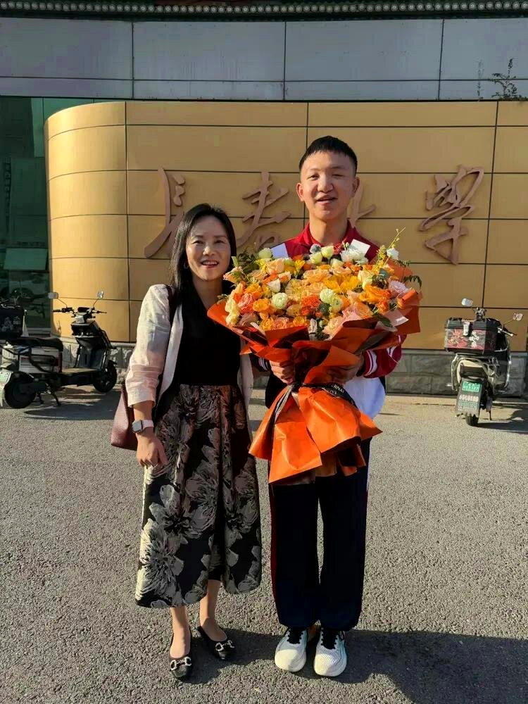 张龙老师(左一)陪伴郭斌(右)到长春大学报到。(取材自极目新闻)