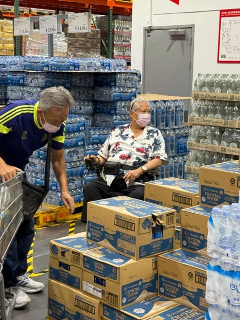 洪金宝近日再度现身深圳超市，独自坐着轮椅来到瓶装水货架前挑选饮用水。（取材自微博...
