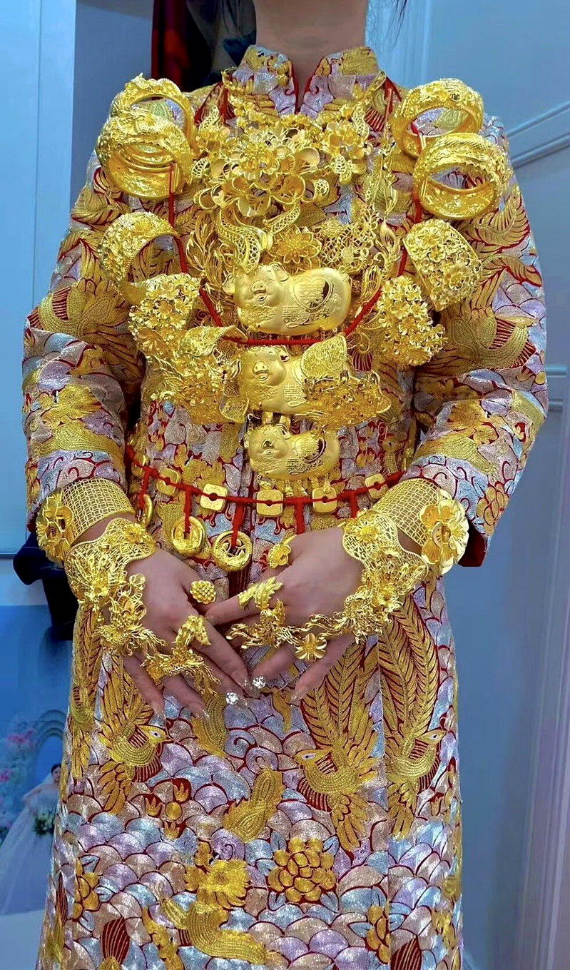 新娘身上挂满三五、五金的传统彩礼。(取材自微博)