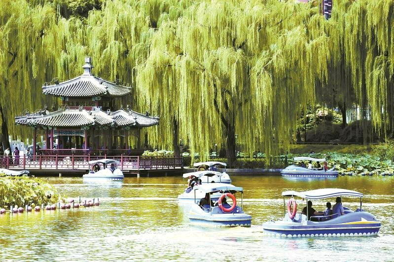 游人在北京陶然亭公园乘坐游船。(本报北京传真)