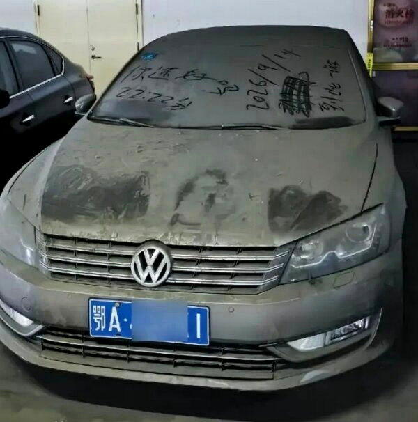 一辆挂着武汉车牌的大众轿车,停在河南信阳东站停车场近7年未驶离,车身覆盖着厚厚灰...