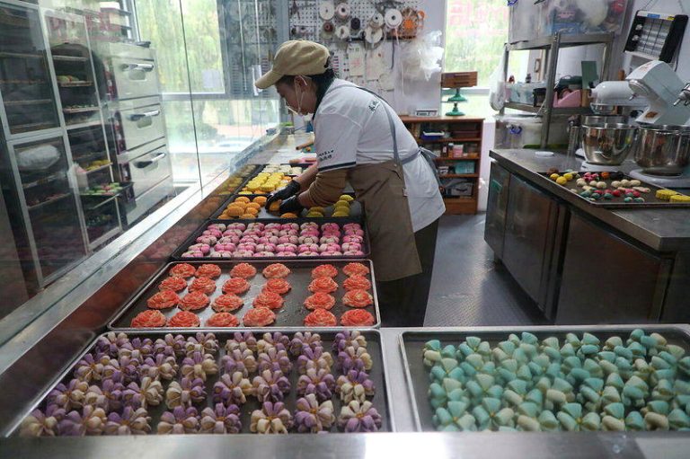 中国没卖完的月饼去哪了? 过期以吨计变成猪饲料 面点师正在制作月饼。示意图。(中新社)