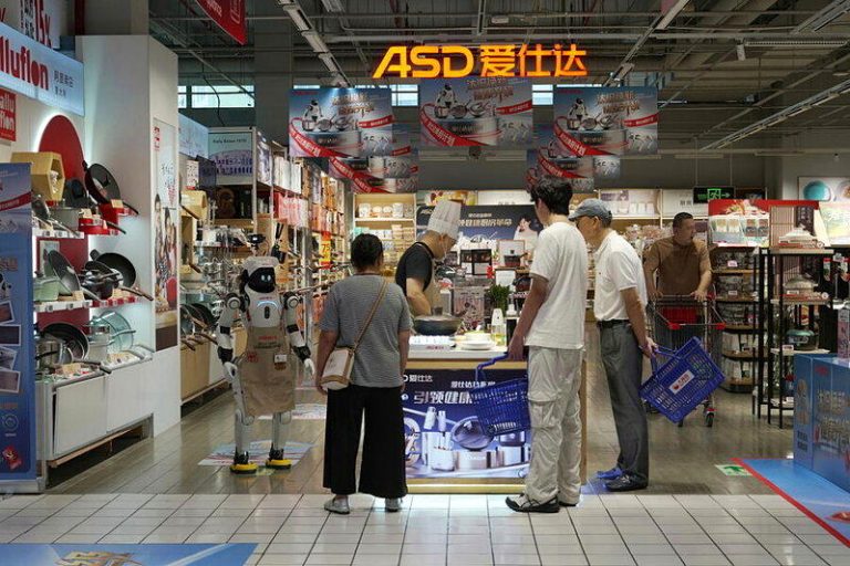 智元灵犀X2机器人「爱宝」在厨具品牌「爱仕达」门市当导购，服务上门的消费者。(取...