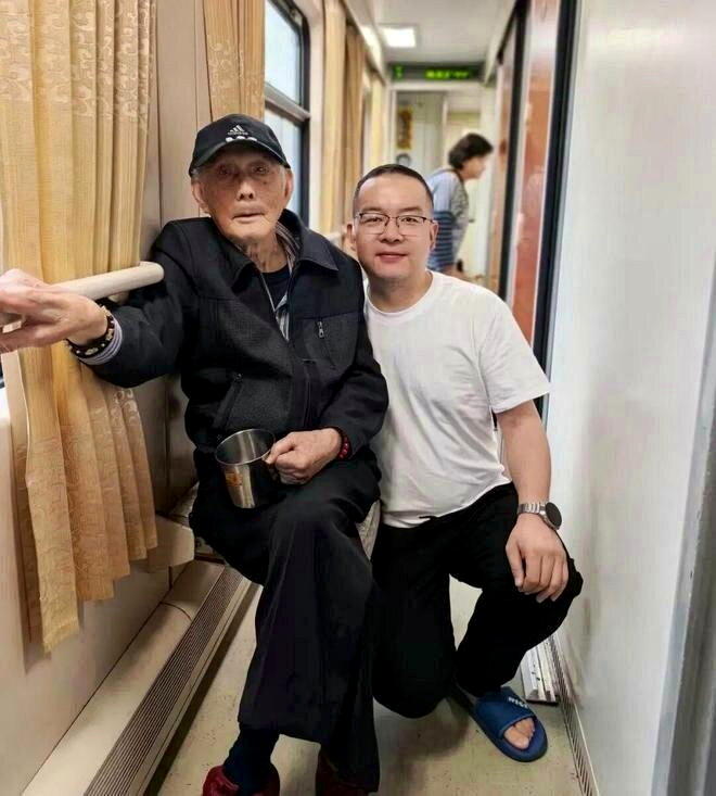 其他游客在火车上和老人合影。(取材自西藏日报)