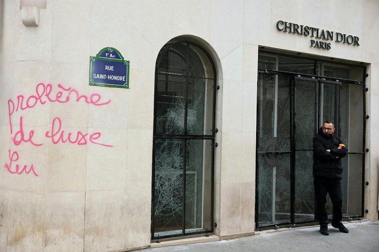 法国暴动 Dior「黑衣保镖大队」镇守巴黎旗舰店 照片疯传 一名保全人员站在遭到洗劫破坏的迪奥(Christian Dior)精品店面外。(...