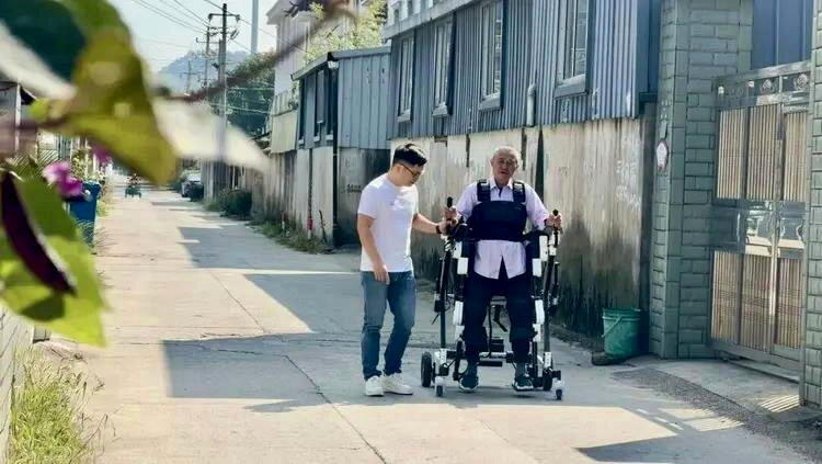 张柯锋带父亲在村里遛弯。（取材自宁波晚报）