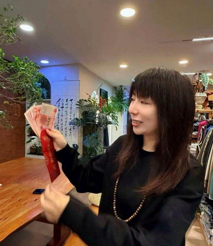 朱朱展示王书明悄悄留下的1000元红包,感动得红了眼眶。(取材自极目新闻)