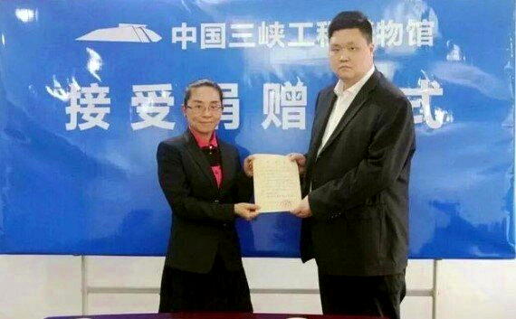 王雨(右)将收款单捐给了三峡工程博物馆。(取材自蓬勃新闻)