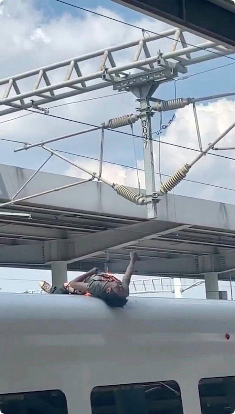 一名男旅客在柳州站D1884次列车开出前爬上车顶,遭架空接触网高压电击。(视频截...