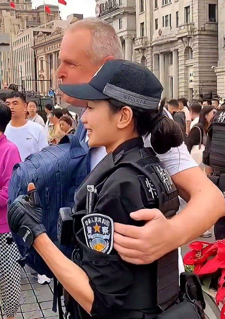 上海女特警钱雪颖应邀与一名外国男游客合照时，对方突然搂住她的上臂。（取材自微博）