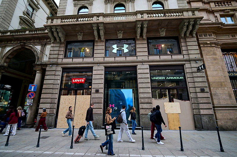 忧心暴动再起,米兰不少知名品牌服饰电周一依旧关闭,店家用木板封住门。(美联社)